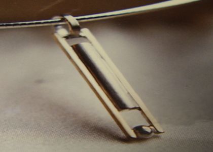Strakke ashanger; een zilveren koker en grijze parel, omlijst door geelgouden staven