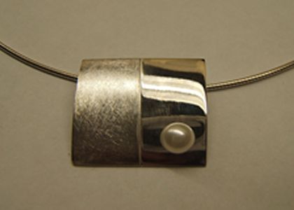 Zilveren hanger rechthoekig, gebold met witte parel, de linker helft is gematteerd