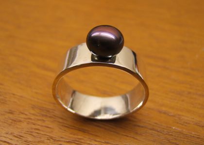 Strakke zilveren ring met paarse parel uit een workshop