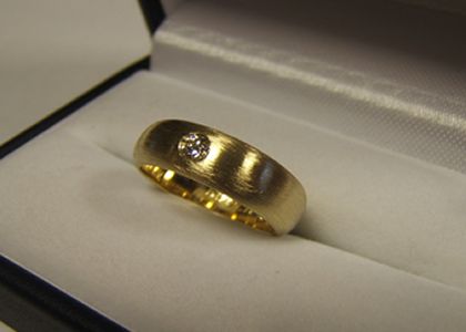 Een massieve gouden ring met steen ontstaan uit twee trouwringen